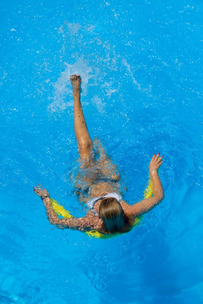 Vue de dessus d'une participante en pleine séance d'aquagym, profitant des bienfaits de l'exercice aquatique pour tonifier son corps.