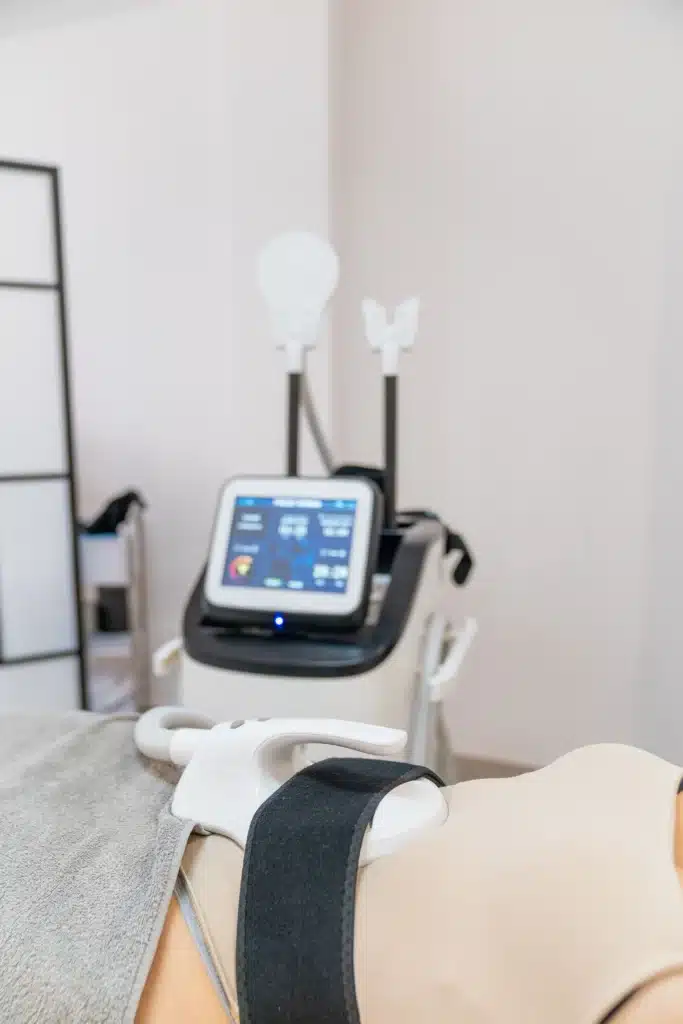 Appareil d'électrostimulation en fonctionnement pendant une séance de fitness, visant à tonifier les muscles.